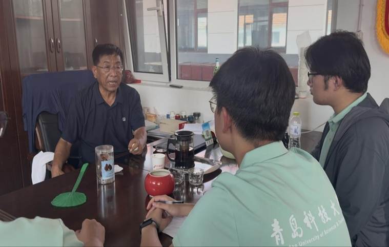 图为高维玉书记给实践团成员介绍村内情况